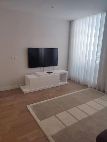 a living room with a flat screen tv on a white cabinet at Terro Collection - São Vicente 78 in Braga