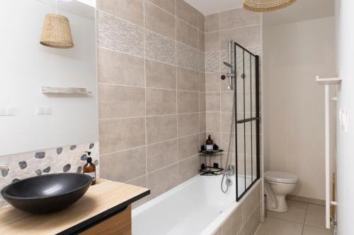 a bathroom with a black sink and a tub at Le Cèdre du Bassin - Au cœur de la Teste in La Teste-de-Buch