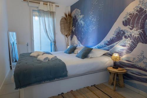 a bedroom with a bed with a blue wall at Le Cèdre du Bassin - Au cœur de la Teste in La Teste-de-Buch
