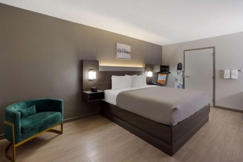 哥倫比亞的住宿－傑克遜堡品質酒店，酒店客房,配有一张床和一把绿色椅子