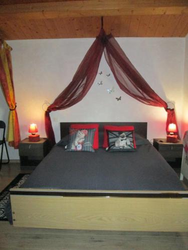 マランにあるLe Petit Sableauのベッドルーム1室(大型ベッド1台、赤い枕付)