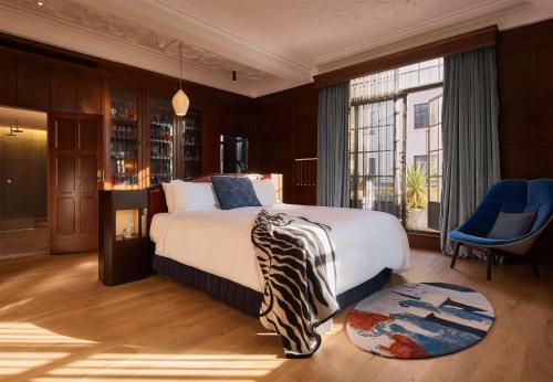 a bedroom with a large bed and a large window at QT Sydney in Sydney