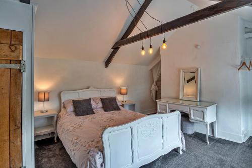a bedroom with a white bed with two tables and a mirror at Finest Retreats - Heath Hills in Okehampton