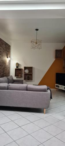een woonkamer met een bank en een tv bij La brique rouge - Maison 66 m2 avec 2 chambres in Lille