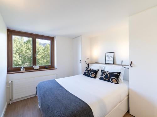 a white bedroom with a large bed and two windows at Appartement Courchevel, 3 pièces, 5 personnes - FR-1-568-30 in Courchevel