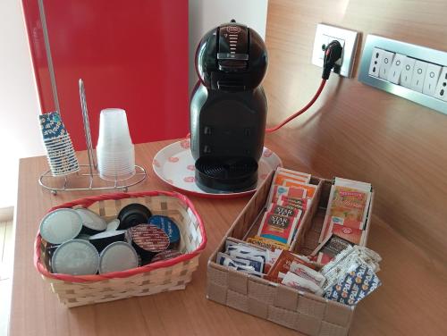 una mesa con cafetera y una cesta de comida en Sweet holidays en Matera