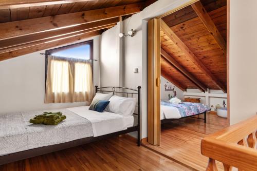 アテネにあるAngi&George houseの木製の天井のベッドルーム1室(ベッド2台付)