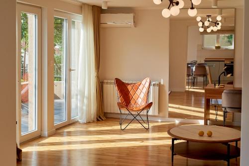 a living room with a chair and a table at 2montenegro MIMOZA Apartments in Dobrota