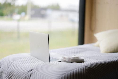 a laptop computer sitting on top of a bed at Hotel OmaBox - Ylivieska - Oma huoneisto saunalla in Ylivieska