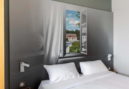 um quarto com uma cama e uma grande janela em B&B HOTEL Troyes Saint-Parres-aux-Tertres em Saint-Parres-aux-Tertres