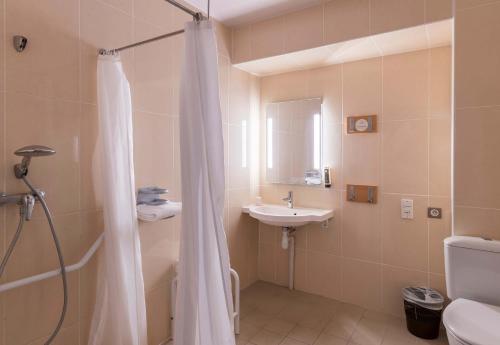 y baño con cortina de ducha y lavamanos. en B&B HOTEL Troyes Saint-Parres-aux-Tertres, en Saint-Parres-aux-Tertres