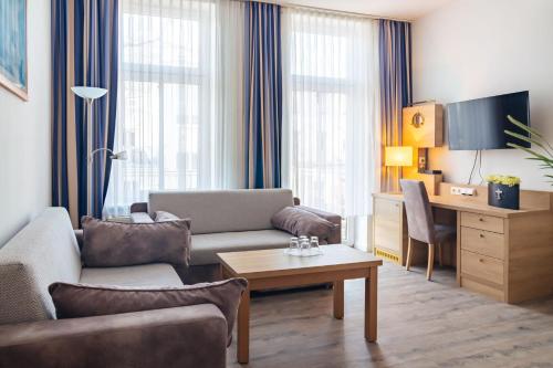 a living room with a couch and a table at Hanse Appartments II Warnemünde mit Parkplatz in Warnemünde
