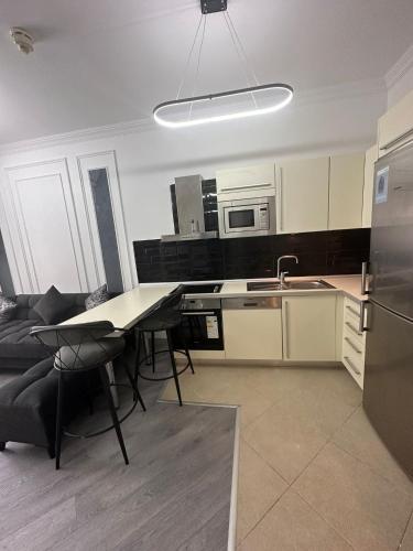 eine Küche mit einem Tisch und Stühlen sowie einem Kühlschrank in der Unterkunft AKBATI MALL LUXURY APARTMENT in Esenyurt