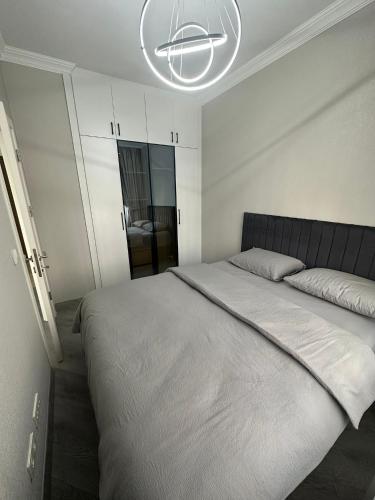 Un dormitorio con una cama grande y una lámpara de araña. en AKBATI MALL LUXURY APARTMENT en Esenyurt