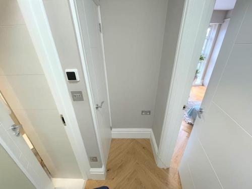 um corredor vazio com uma pessoa a chegar a uma porta em Large South Facing Studio Flat em Londres