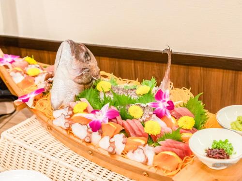 a plate of food with a fish and flowers on it at LiVEMAX RESORT Kusatsu Onsen in Kusatsu