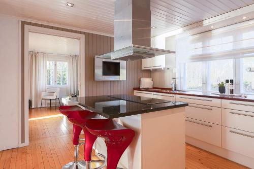 a kitchen with a counter and red stools in it at Skomakerhuset in Løten