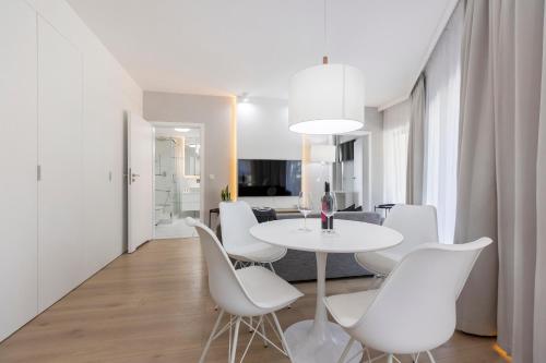 a white dining room with a white table and white chairs at Grand Laola Spa in Pobierowo