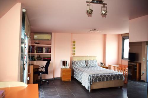 a bedroom with a bed and a desk and a chair at Dux penthouse Acropolis View byMK in Athens