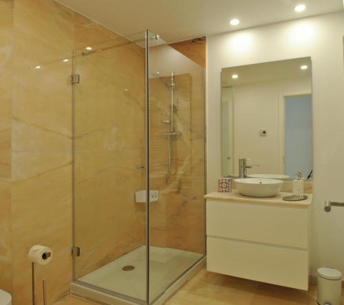 a bathroom with a glass shower with a sink at Alfama Prime Apartments by Homing in Lisbon