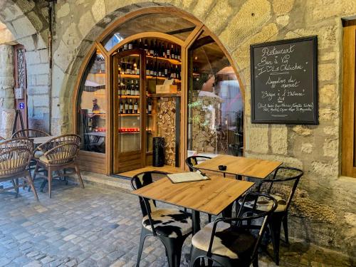 un restaurant avec des tables et des chaises en bois devant un magasin dans l'établissement L Esperance rue du paquier, à Annecy