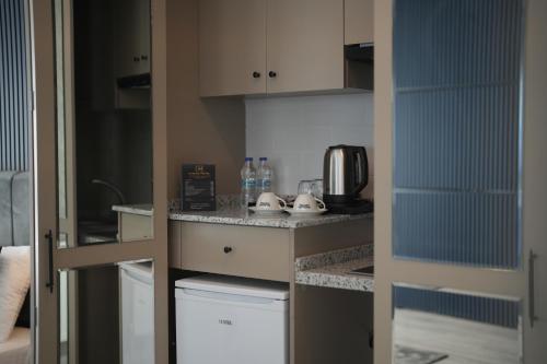 a small kitchen with white cabinets and a microwave at Marlen Hotel Bayraklı in Bayrakli