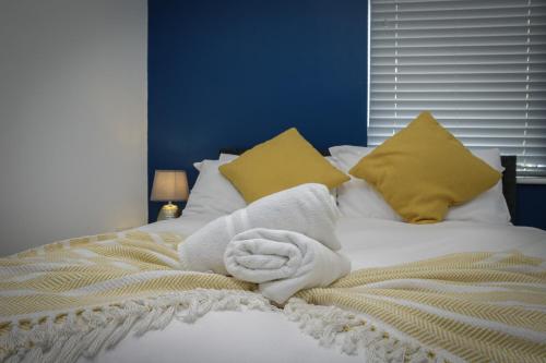 a bed with a pile of towels on it at Blackpool Abode - 20 Bairstow Street in Blackpool