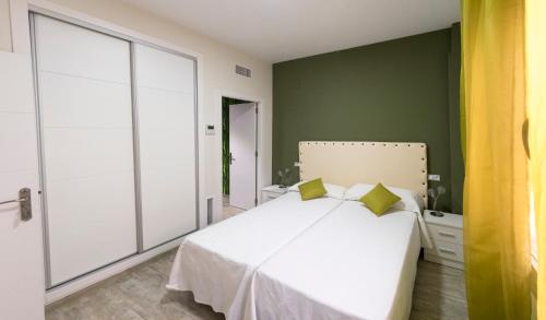 una camera con letto bianco e pareti verdi di CASA CON PATIO a Pozoblanco