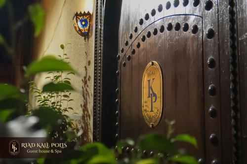 a wooden door with a gold sign on it at RIAD KALE POLIS in Marrakech