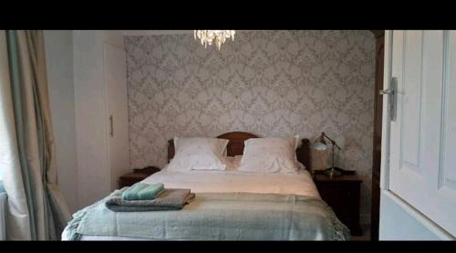 a bedroom with a bed with a pillow and a chandelier at Wingfield House 3 Bed in Greasbrough
