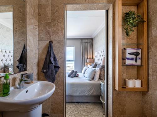 ein Badezimmer mit einem Waschbecken und ein Schlafzimmer mit einem Bett in der Unterkunft Beach life in Summerstrand