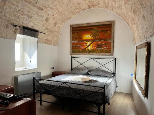 a bedroom with a bed with a painting on the wall at Trullo Sofia in Monopoli
