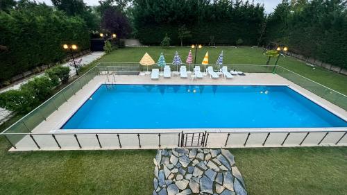 einen großen Pool mit Stühlen in der Unterkunft Private Villa with Swimming Pool in Türkoba