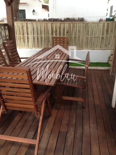 a wooden table and chairs on a wooden deck at SA TANCA in Cala Blanca
