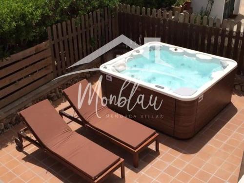 a hot tub with two chairs and a bench at SA TANCA in Cala Blanca