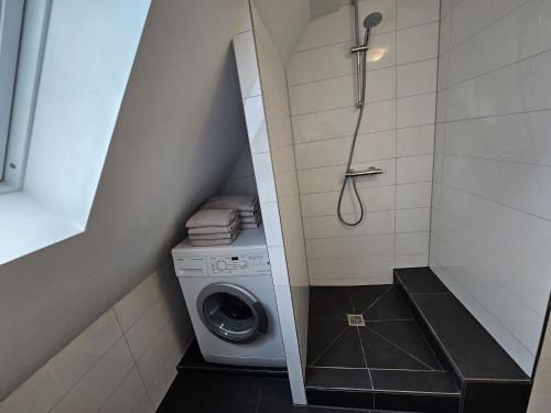 a small bathroom with a washing machine and a shower at Ferienwohnung zur Grenze in Gronau