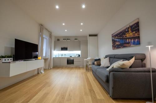 ein Wohnzimmer mit einem Sofa und einem Flachbild-TV in der Unterkunft Veroniamo in Verona