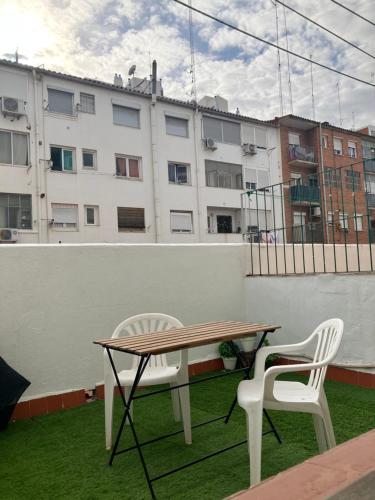 Disfruta tu estancia en Zaragoza! في سرقسطة: طاولة وكرسيين على شرفة مع مبنى