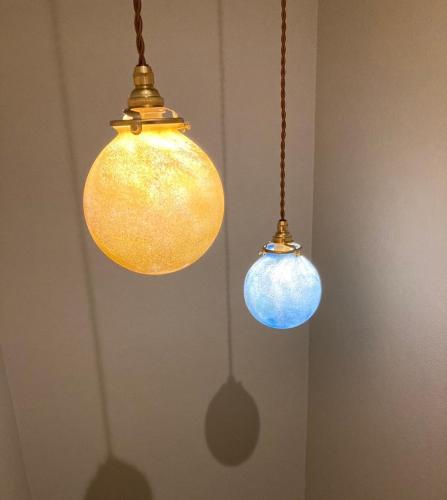 two lights are hanging from the ceiling in a room at COUSCOUS Glamping Manazuru in Manazuru