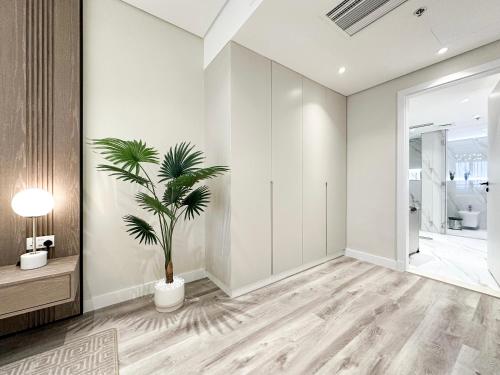 een woonkamer met een plant in een vaas bij Fabulous 1 bedroom apartment at 5 Star Resort in Dubai