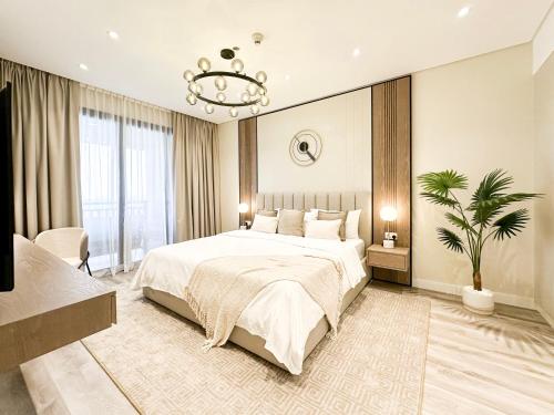 een slaapkamer met een groot bed en een kroonluchter bij Fabulous 1 bedroom apartment at 5 Star Resort in Dubai