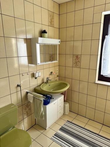 a bathroom with a green sink and a mirror at Ferienwohnung Schömberg in Schömberg