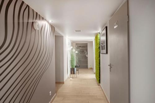 a hallway with white walls and a wooden floor at Grand Laola Spa in Pobierowo