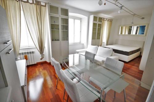 ein Wohnzimmer mit einem Glastisch und weißen Stühlen in der Unterkunft Appartamento in viale in Triest