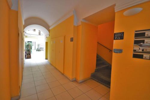 einen Flur mit orangefarbenen Wänden und Fliesenboden in der Unterkunft Appartamento in viale in Triest