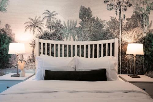 una camera da letto con un grande letto bianco con due lampade di Cosy Holiday home in heart of London a Londra