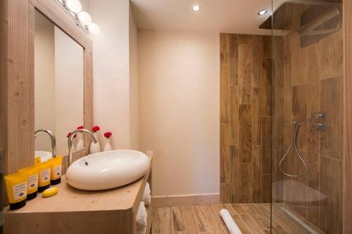 La salle de bains est pourvue d'un lavabo blanc et d'une douche. dans l'établissement Chalet Ambre, à Tignes