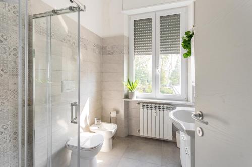une salle de bain blanche avec toilettes et lavabo dans l'établissement Casa Alboino&Teodolinda - Pavia City - by Host4U, à Pavia