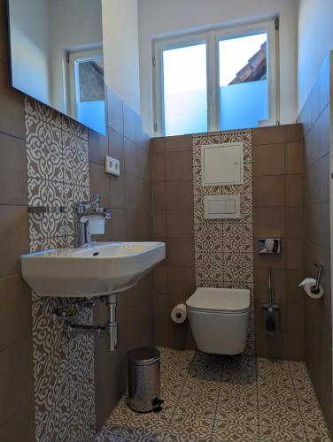 a bathroom with a sink and a toilet and a window at Hotel Fürstenhof in Büdingen