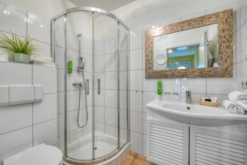 La salle de bains est pourvue d'une douche, de toilettes et d'un lavabo. dans l'établissement Ferienwohnungen Strandgrün, à Timmendorfer Strand